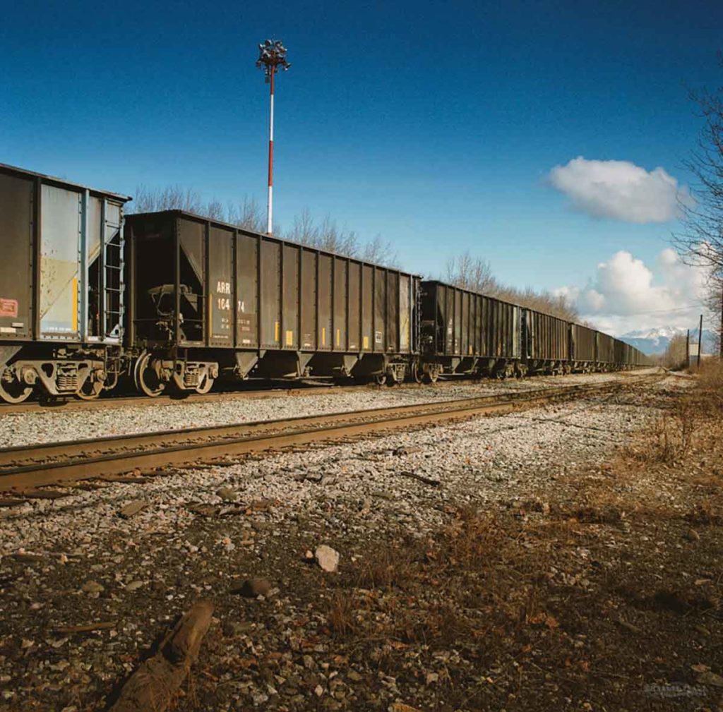 Photo of a train, a line of train cars stretching to the horizon.