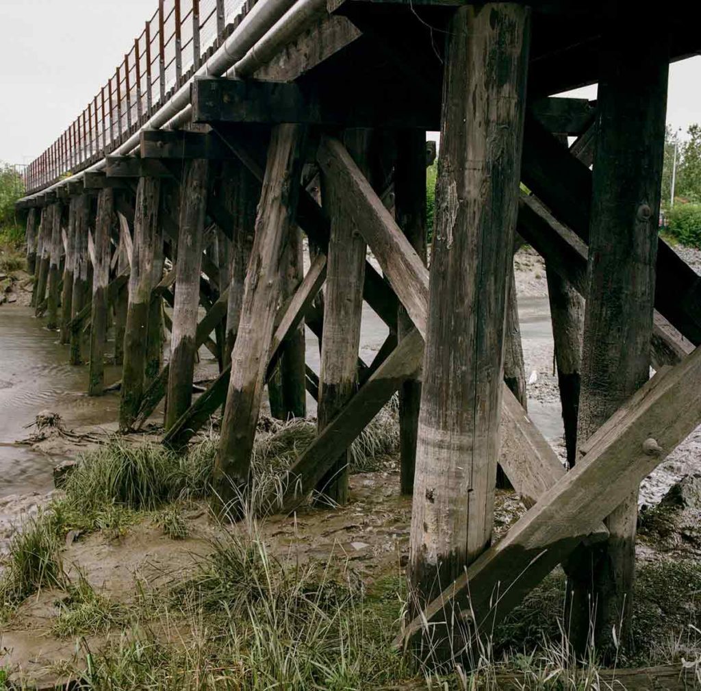 A photo of the support beams inderneath a walkway over a creek in Anchorage, Alaska